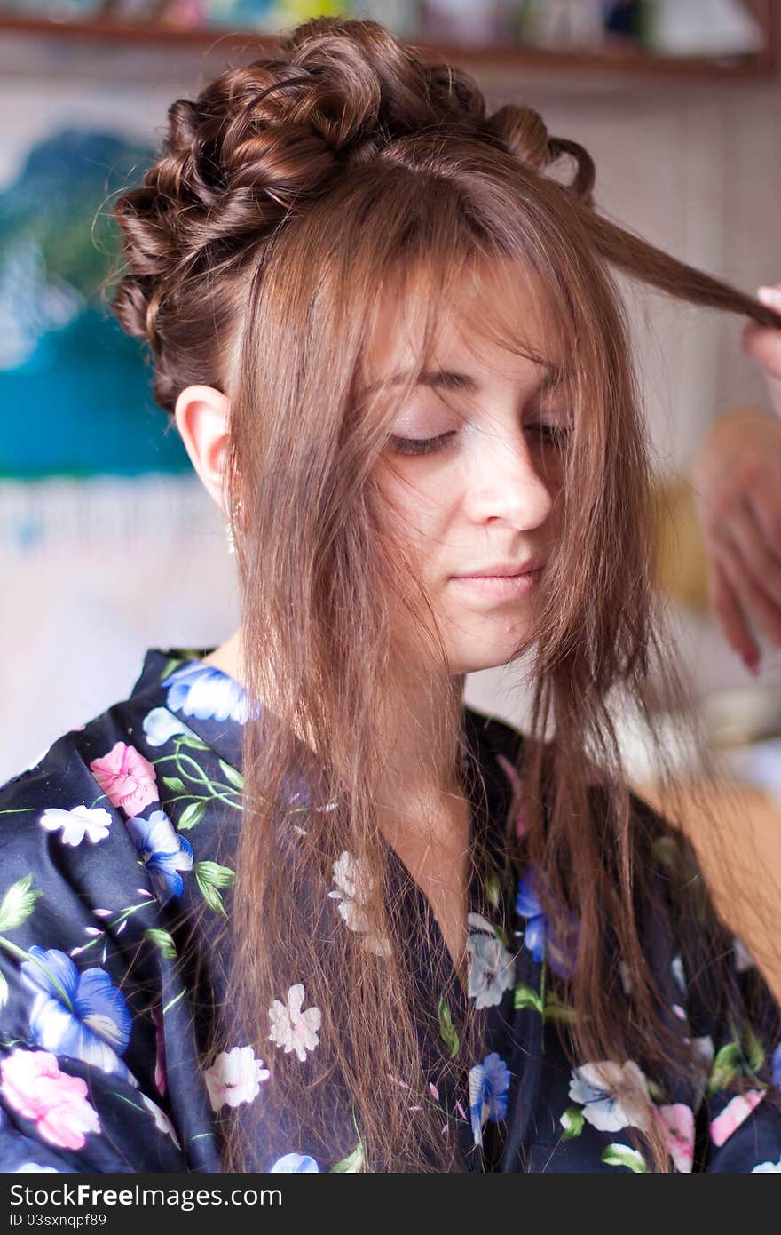 Hands of the hairdresser doing hair to the bride