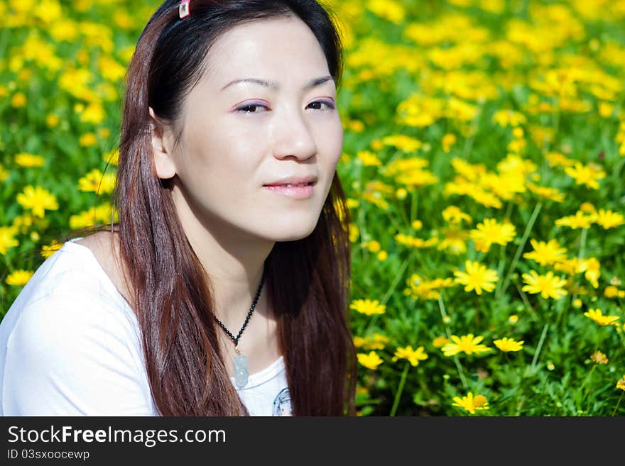 Portrait of the east asian woman, yellow flowers background