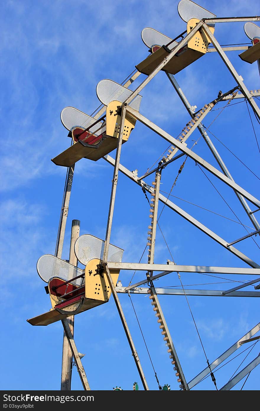 Seats of a ferris wheel against a blue sky