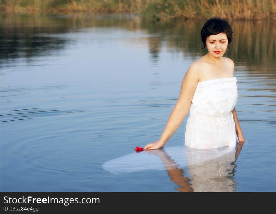 Portrait beautiful young woman with red rose in the water