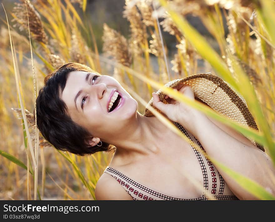 Portrait of beautiful brunette woman in summer reed