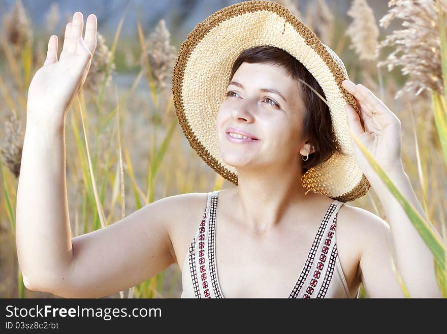 Portrait of beautiful brunette woman in summer reed