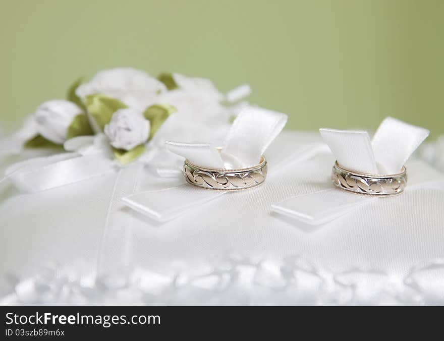 Wedding rings on white pillow