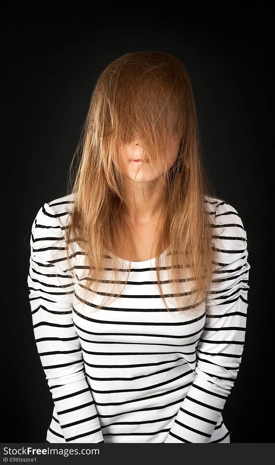 Hair covers her face with a young girl on a black background