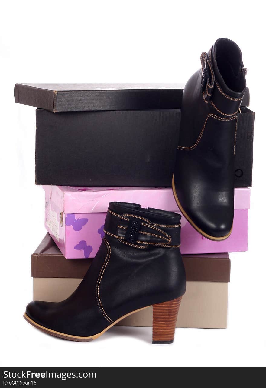 Pair of black winter woman boots and many boxes over white