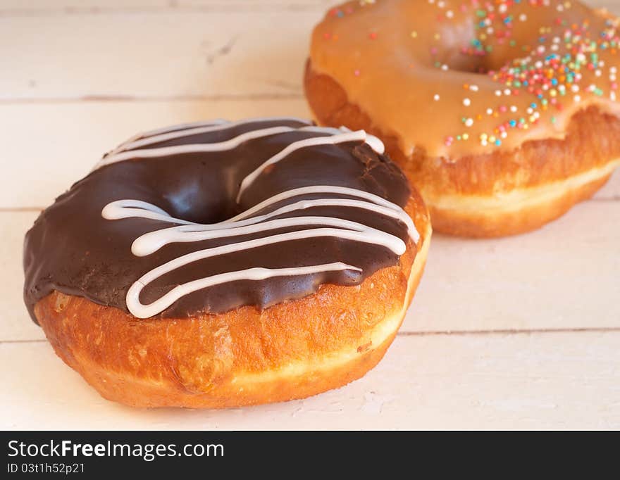 Two Donuts Covered In Caramel And Chocolate Icing