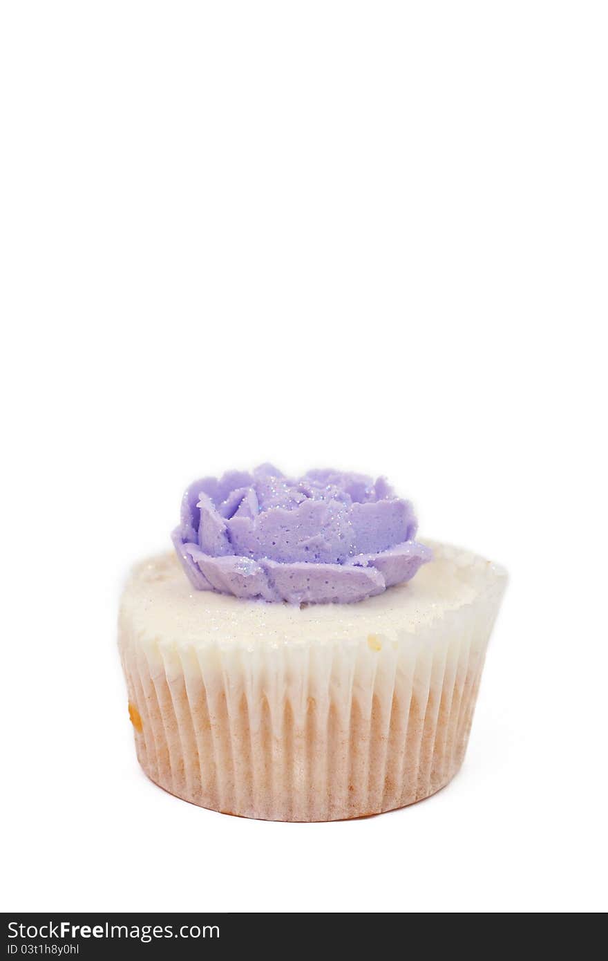 Fresh vanilla cupcake with purple buttercream icing rose on white background. Fresh vanilla cupcake with purple buttercream icing rose on white background