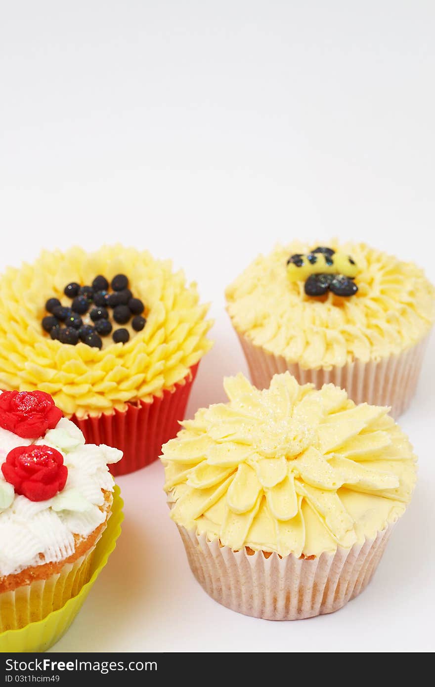 Variety of vanilla cupcakes with various buttercream decorations on light background. Variety of vanilla cupcakes with various buttercream decorations on light background