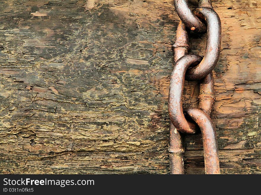 A thick anchor chain on a beached log. A thick anchor chain on a beached log.