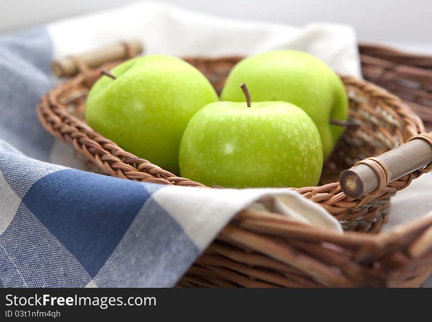 Green apples in the brown wicker basket