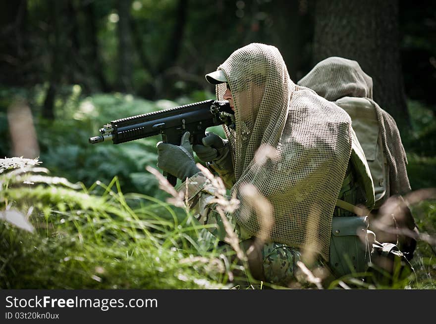 Special forces soldiers in forest during patrol, defending their position. Special forces soldiers in forest during patrol, defending their position.