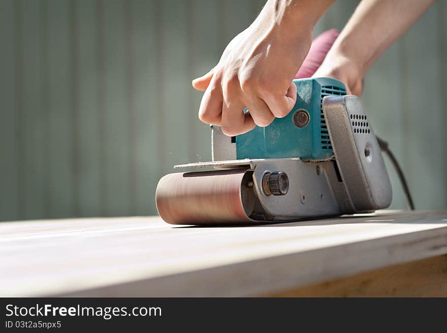 A man working with electrical sanding machine