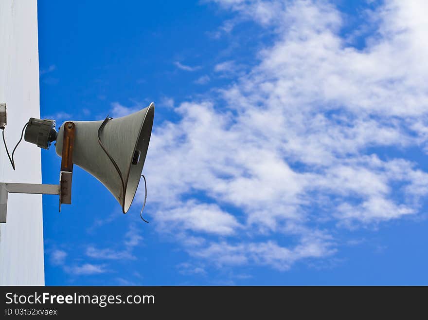 Old loudspeaker against cloudy blue sky. Old loudspeaker against cloudy blue sky