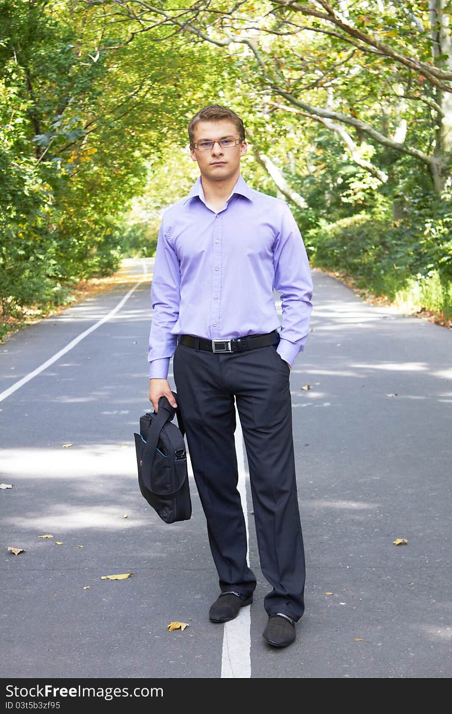 Businessman with computer in a park in autum