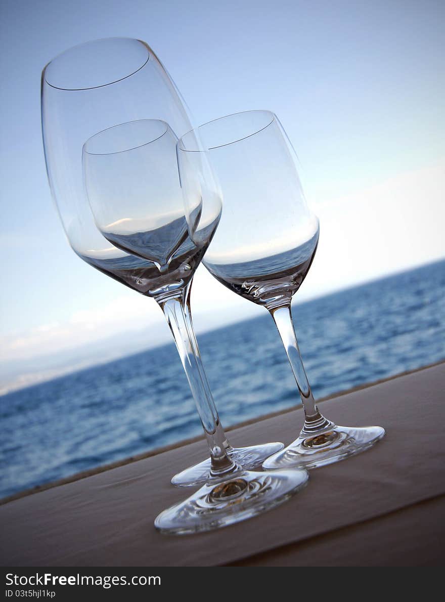 Wine glasses in front of sea and blue sky