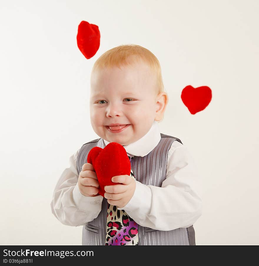 Baby boy with a soft red heart in hands