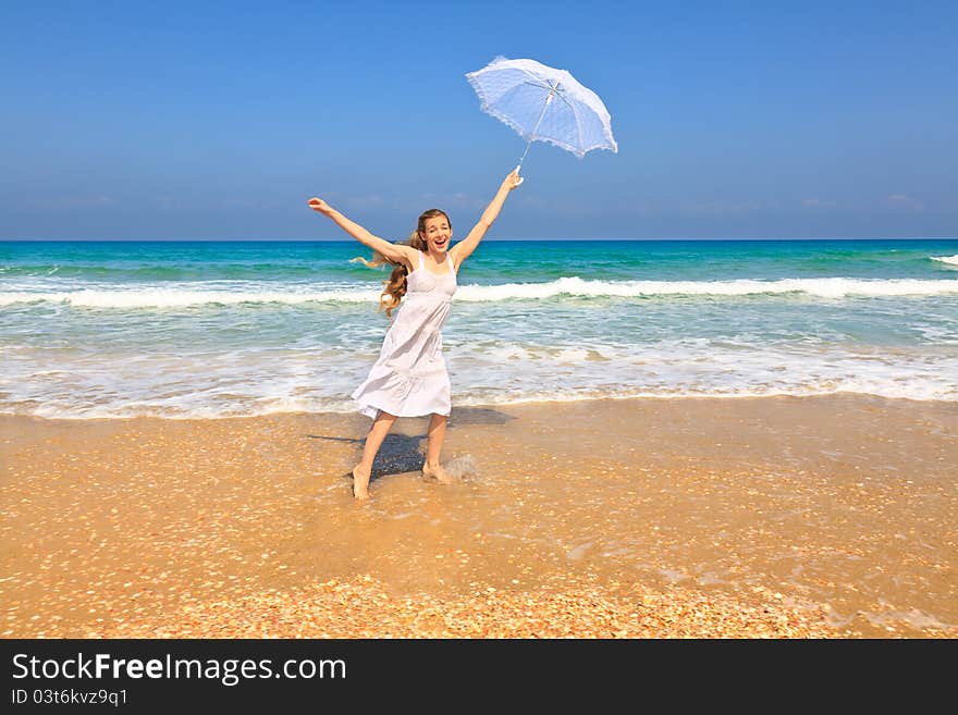 Beautiful girl in white on the beach with umbrella. Beautiful girl in white on the beach with umbrella