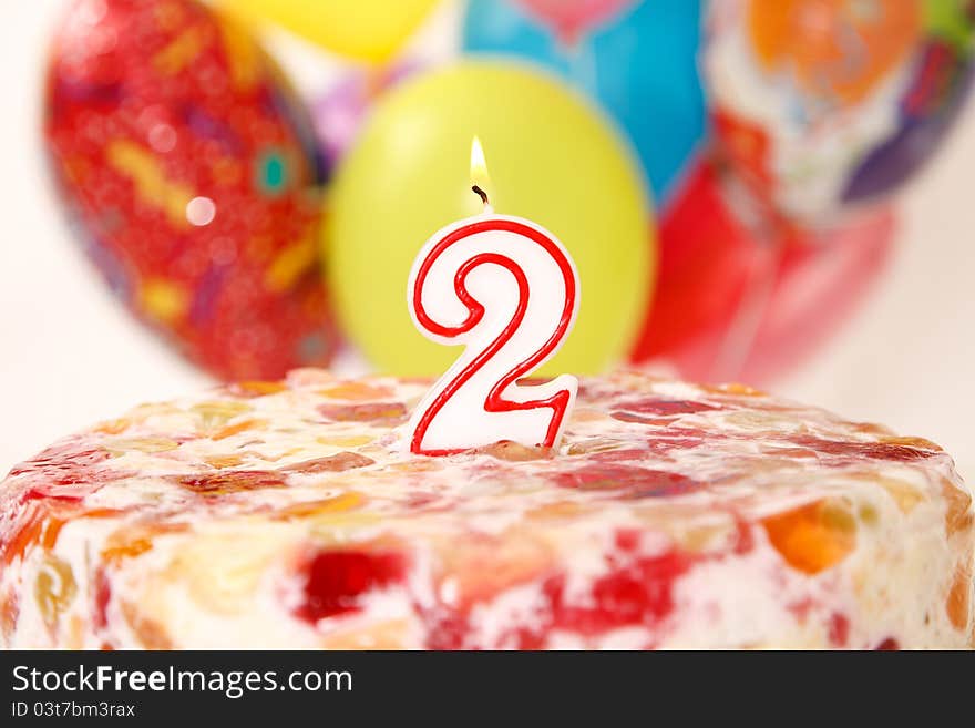 Birthday candle with flame and balloon background