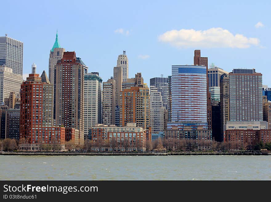 Manhattan skyscrapers, colourful New York City offices and apartments gleaming in the afternoon sun from the Hudson river. Red brick buildings, historic and modern. Manhattan skyscrapers, colourful New York City offices and apartments gleaming in the afternoon sun from the Hudson river. Red brick buildings, historic and modern