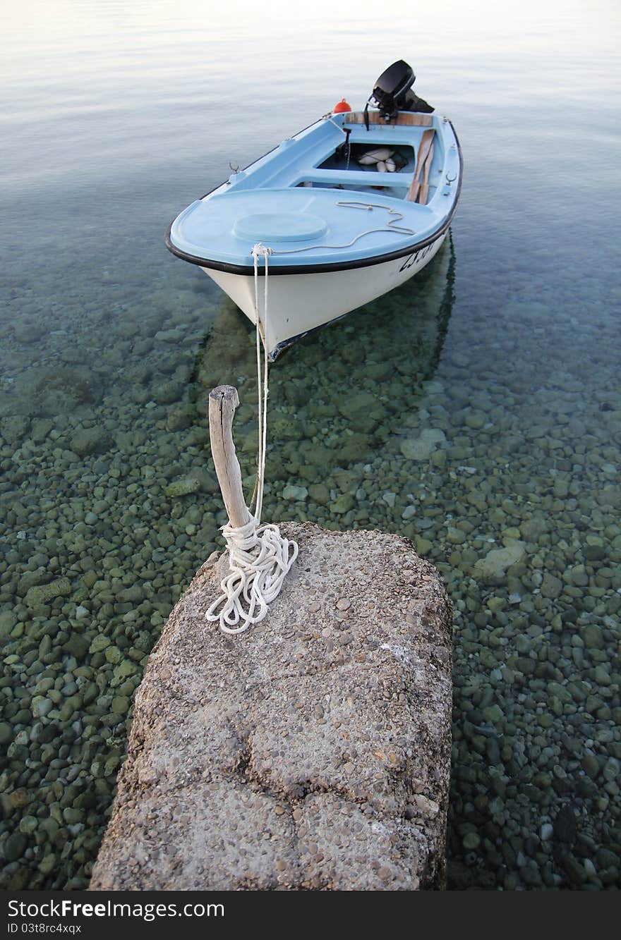 Small boat tied on small old pier