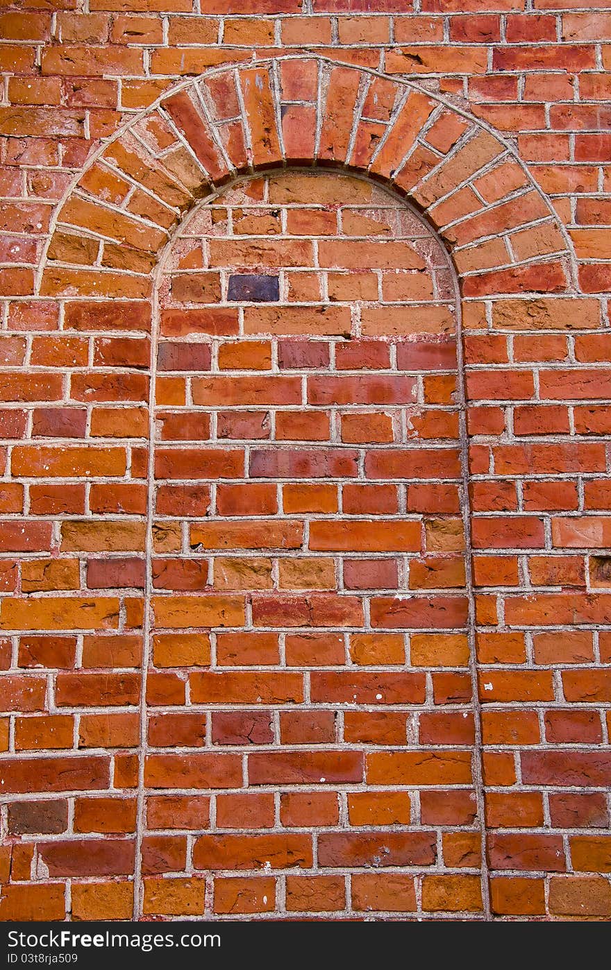 Arch with rounded top mured up with red brick. Architectural wall solutions.