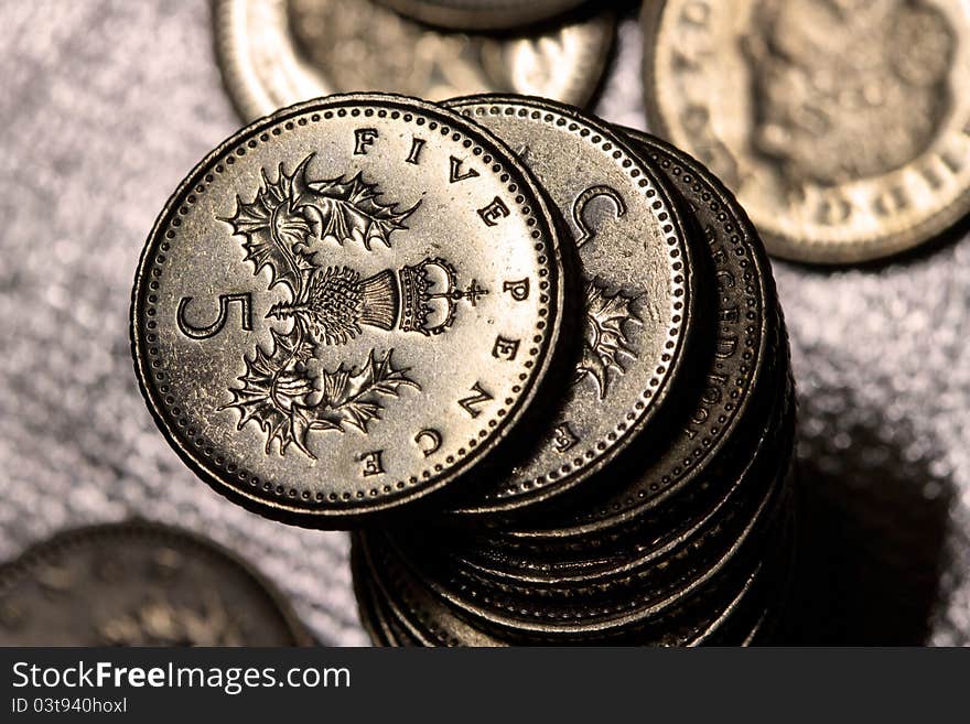 A Pile of Five Pence Coins. Shiny silver background