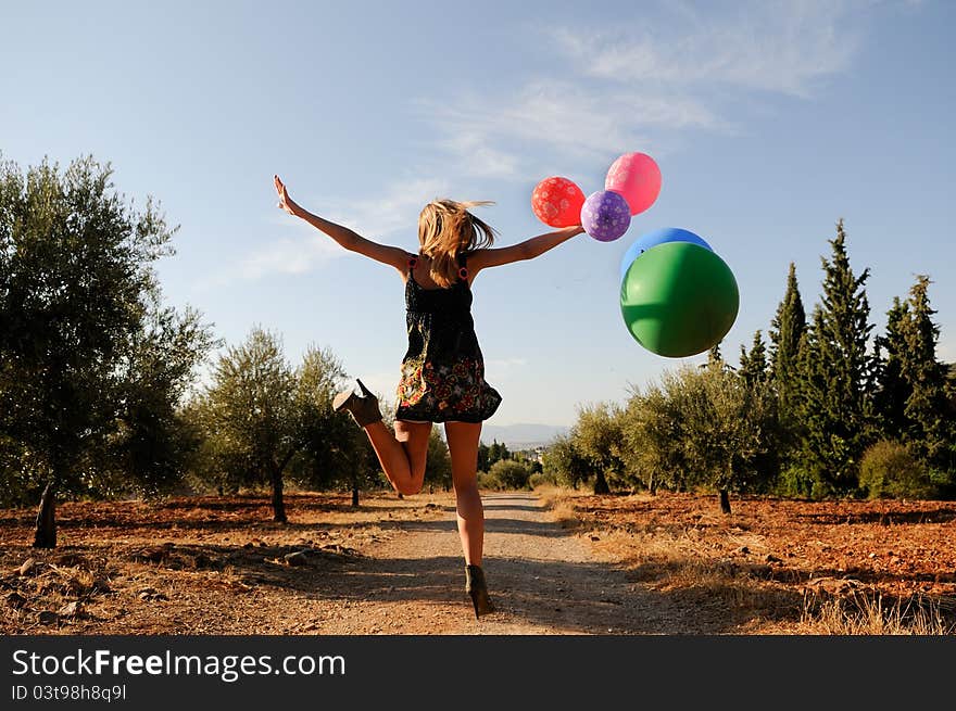 Girl with balloons in the field