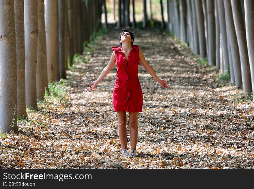 Woman dressed in red, meditating in the forest