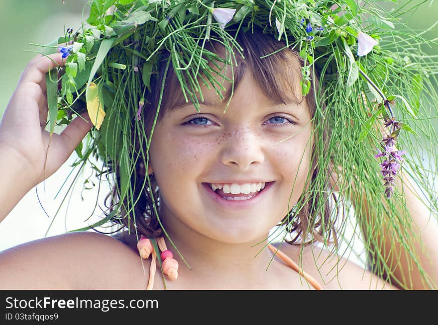 The portrate of lovely smiling girl with a wreath on a head. The portrate of lovely smiling girl with a wreath on a head