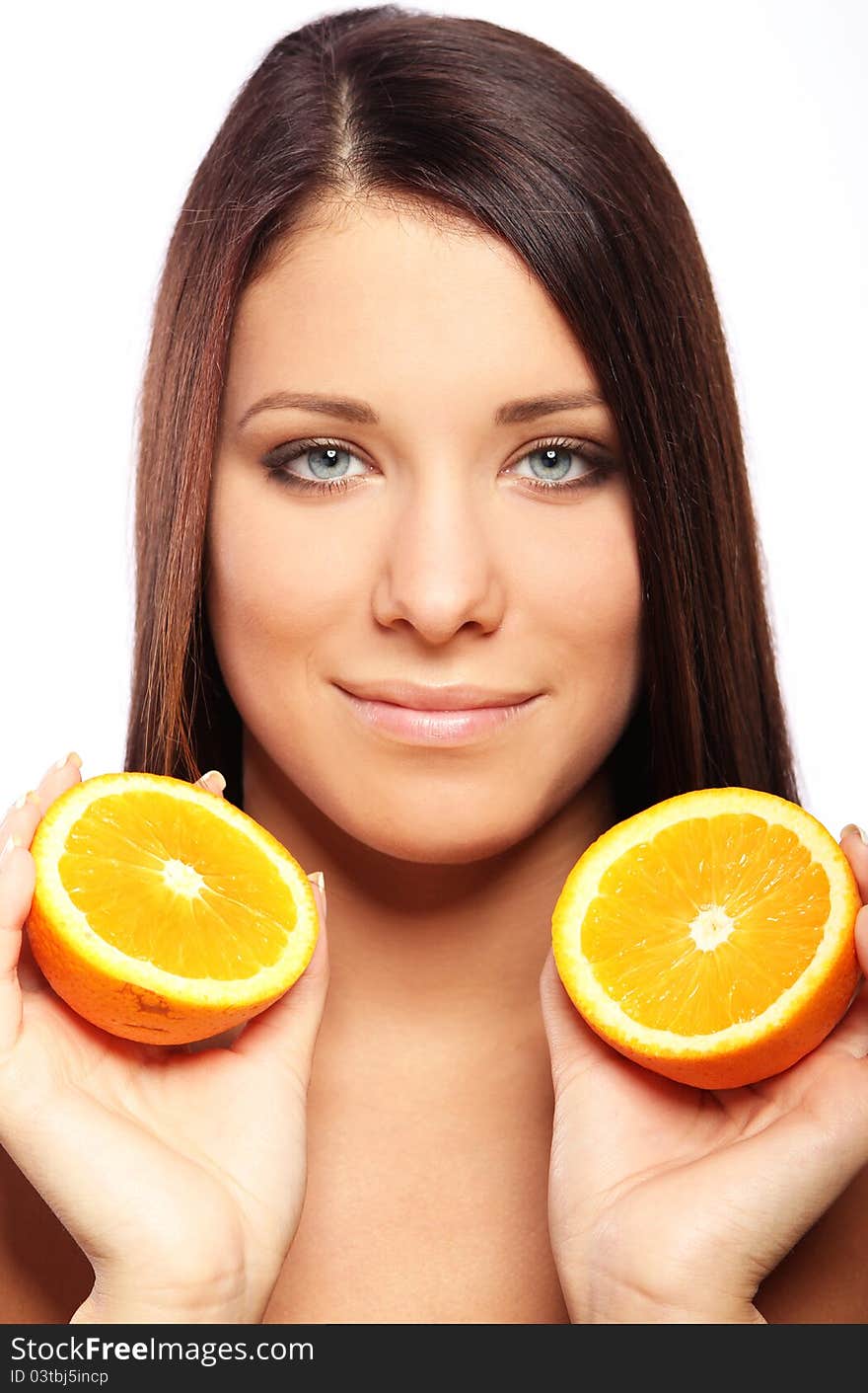 Beautiful woman with orange in hands against white background