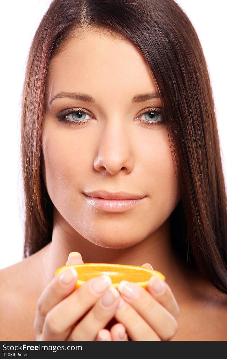 Beautiful woman with orange in hands against white background