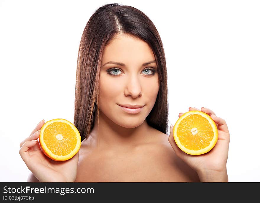 Beautiful woman with orange in hands against white background