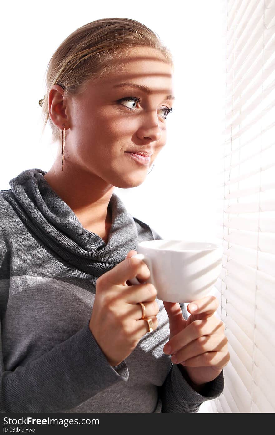 Beautiful Woman With Cup Of Coffee Beside A Window