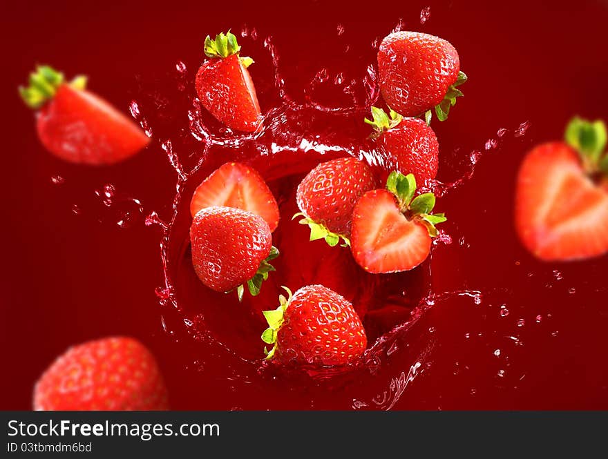 Strawberry falling into the juice with huge splashes. Strawberry falling into the juice with huge splashes