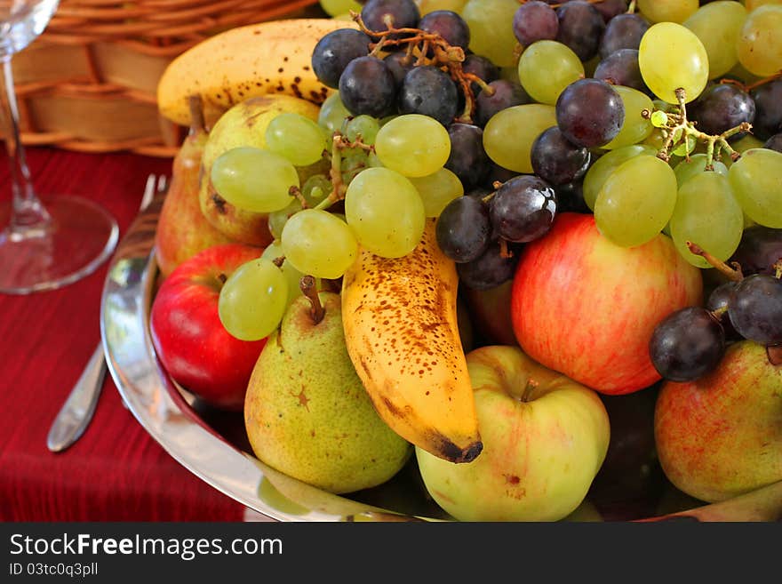 Assorted fruit plateau on red table.