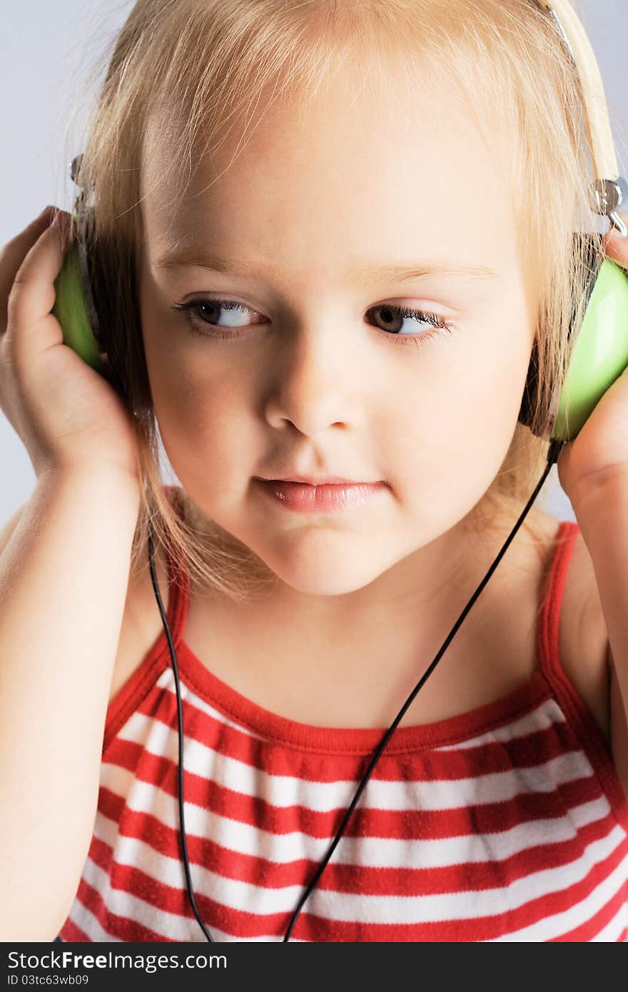 Little girl listening a music in earphones