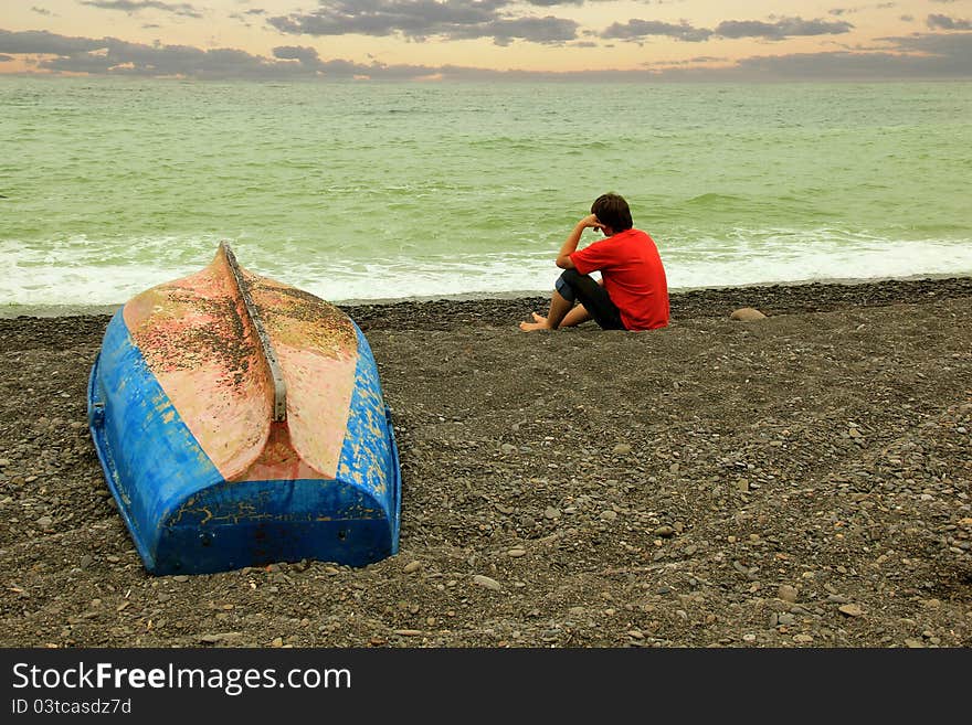 A men and a boat near the sea. A men and a boat near the sea