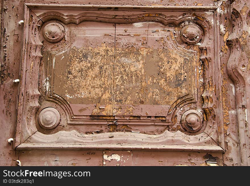 Old wooden door fragment. Architectural ornaments and peeled paint. Old wooden door fragment. Architectural ornaments and peeled paint.