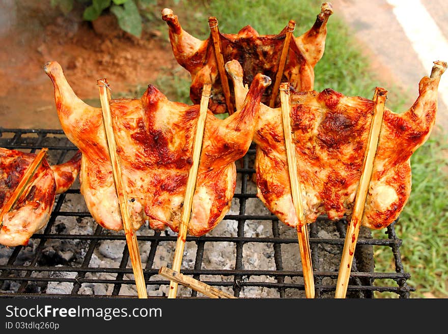 Grilled chicken over gridiron and low heat from natural charcoal