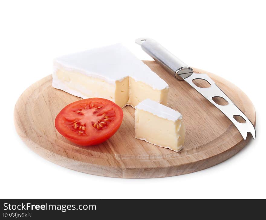 Brie cheese and tomato slice on wood plate isolated