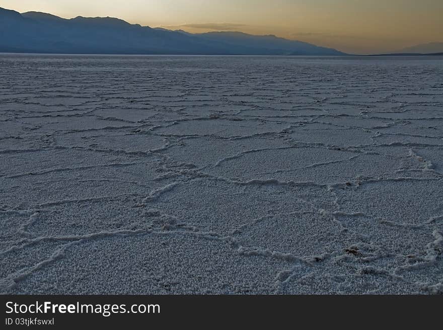 The prismatic sodium borite flats of Death Valley National Park, California (The lowest point in North America) stretch off into the distance under a sunset. The prismatic sodium borite flats of Death Valley National Park, California (The lowest point in North America) stretch off into the distance under a sunset.