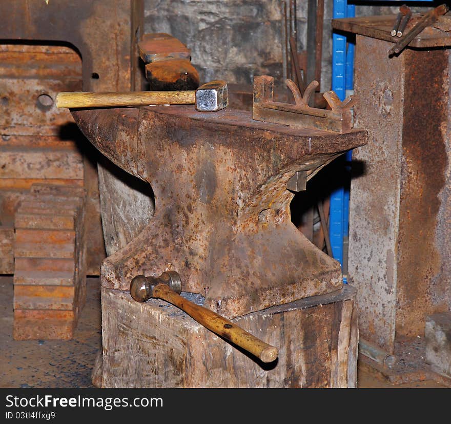 Rusty Iron Anvil in a Machine Shop with Hammer and Mallet. Rusty Iron Anvil in a Machine Shop with Hammer and Mallet