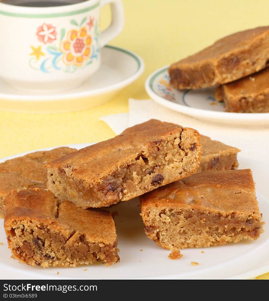 Plate of peanut butter bars with a cup of coffee in background