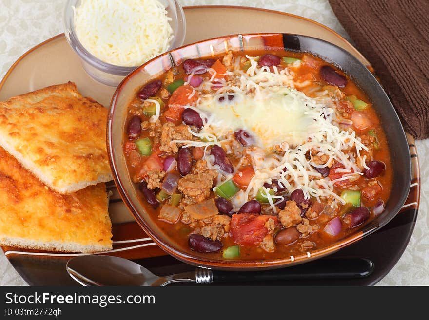 Bowl of chili with melted cheese and cheese bread. Bowl of chili with melted cheese and cheese bread