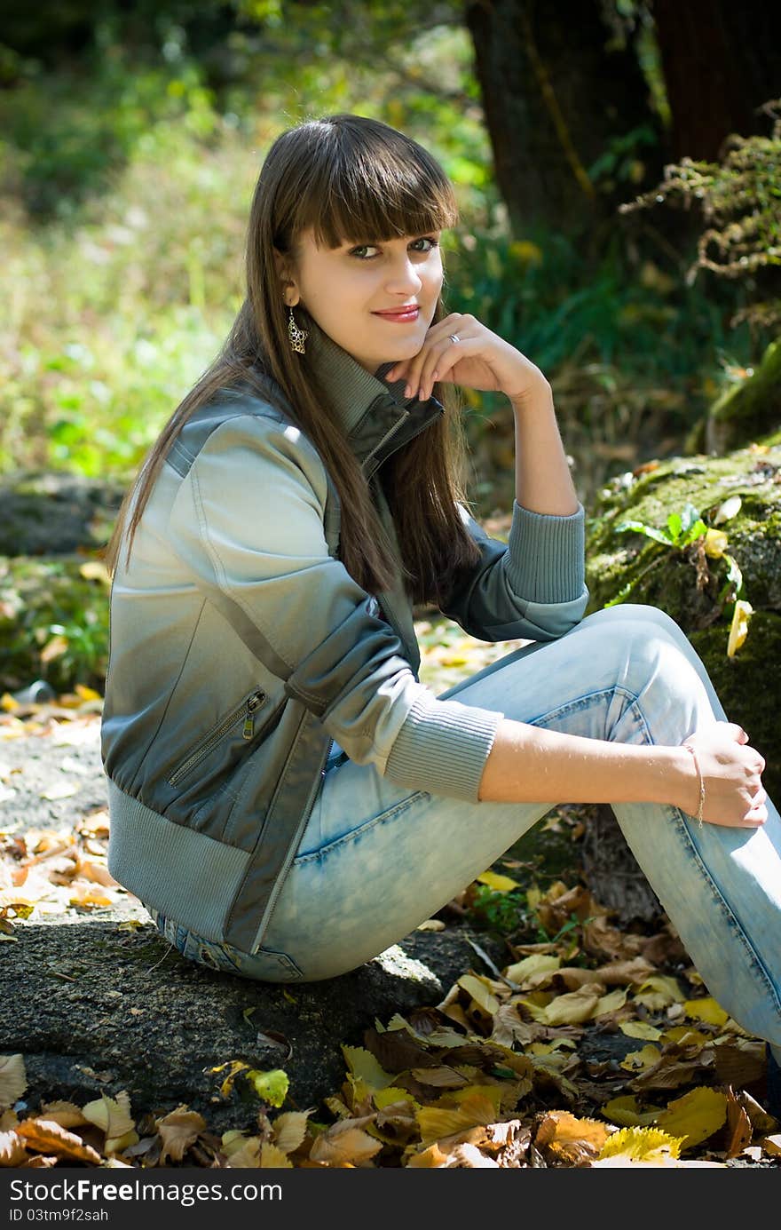 Pretty young woman sitting in park. Pretty young woman sitting in park