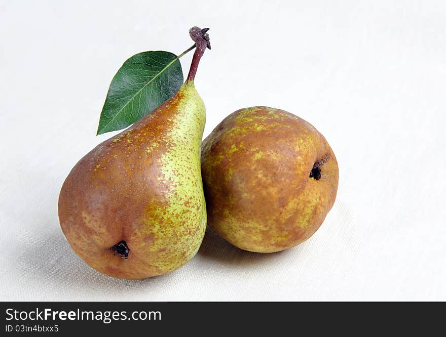 Two mature pears with sheet  on a hessian background. Two mature pears with sheet  on a hessian background