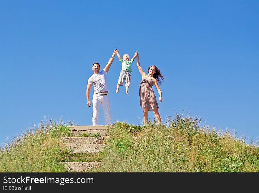 Family under blue sky. Father, mother and son in the park. Family under blue sky. Father, mother and son in the park