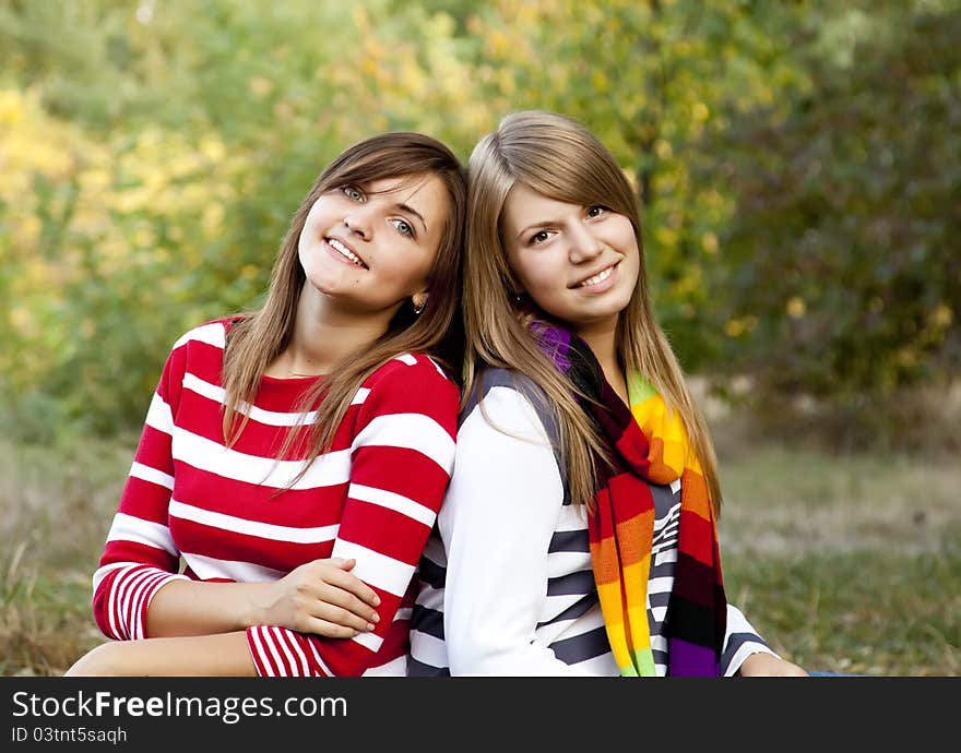 Portrait of redhead and brunette girls at outdoor. Autumn.