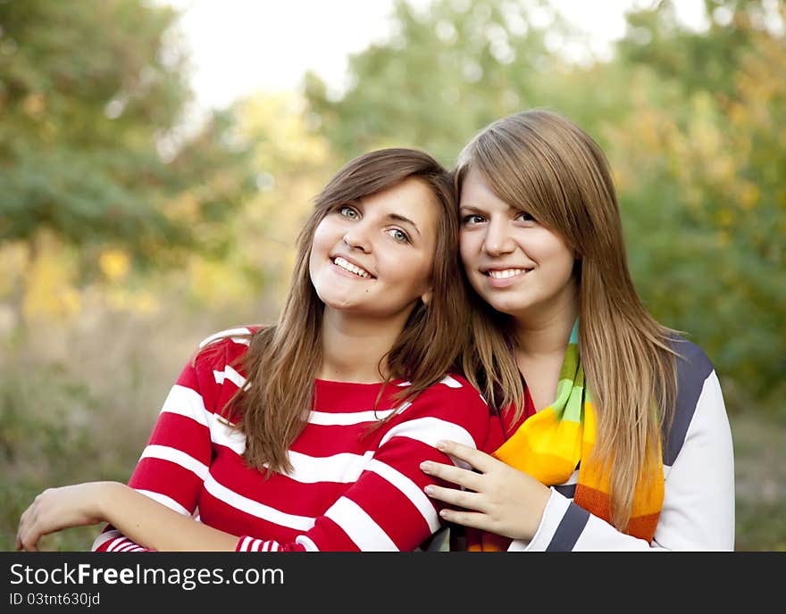 Portrait of redhead and brunette girls at outdoor.