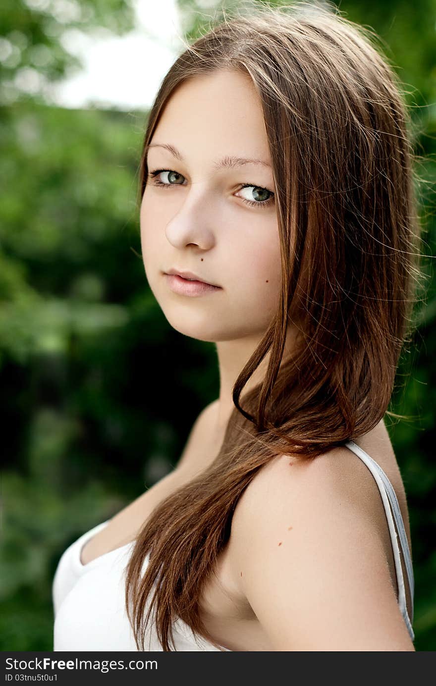 Young woman portrait on green background.